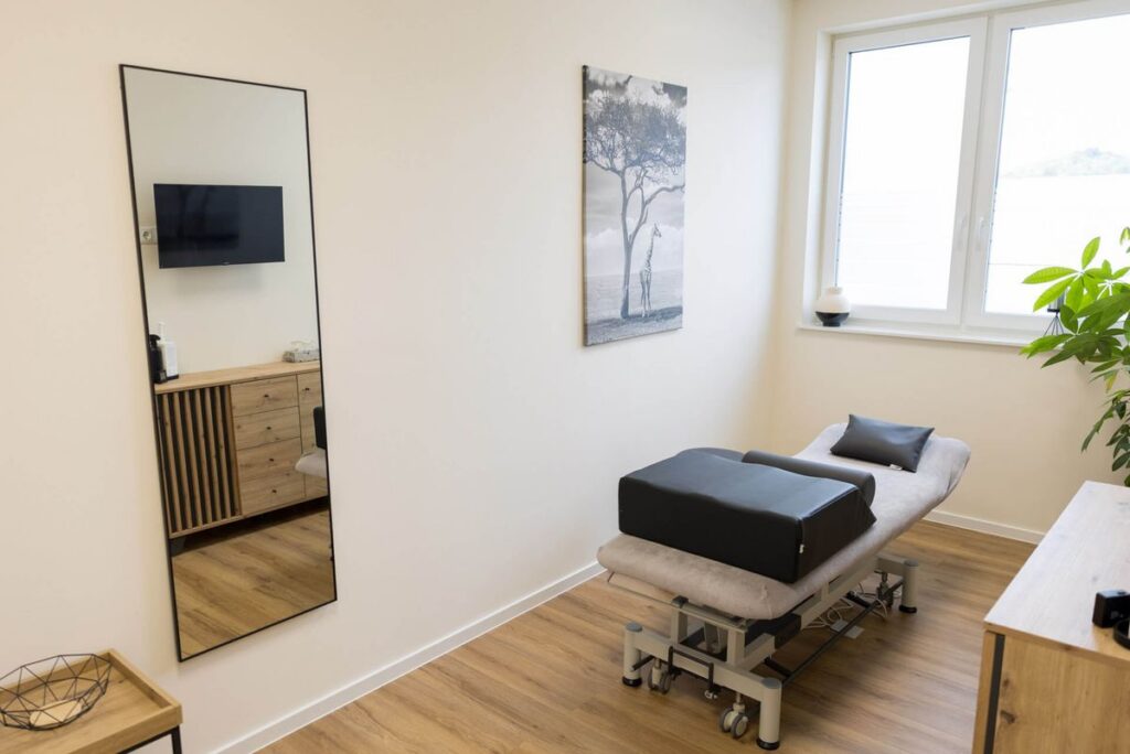 Heller Behandlungsraum mit Therapieliege