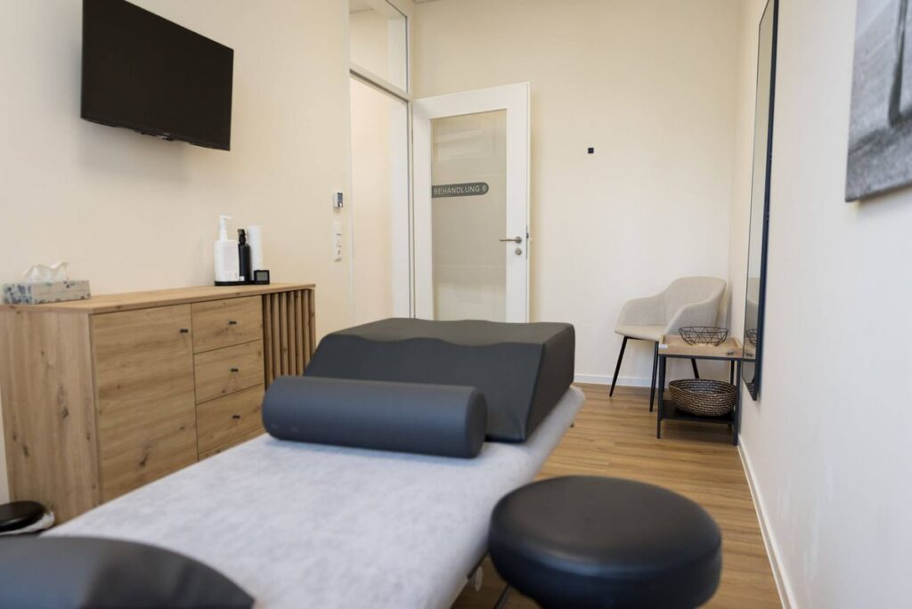Behandlungsraum mit Therapieliege und Lagerungsrollen